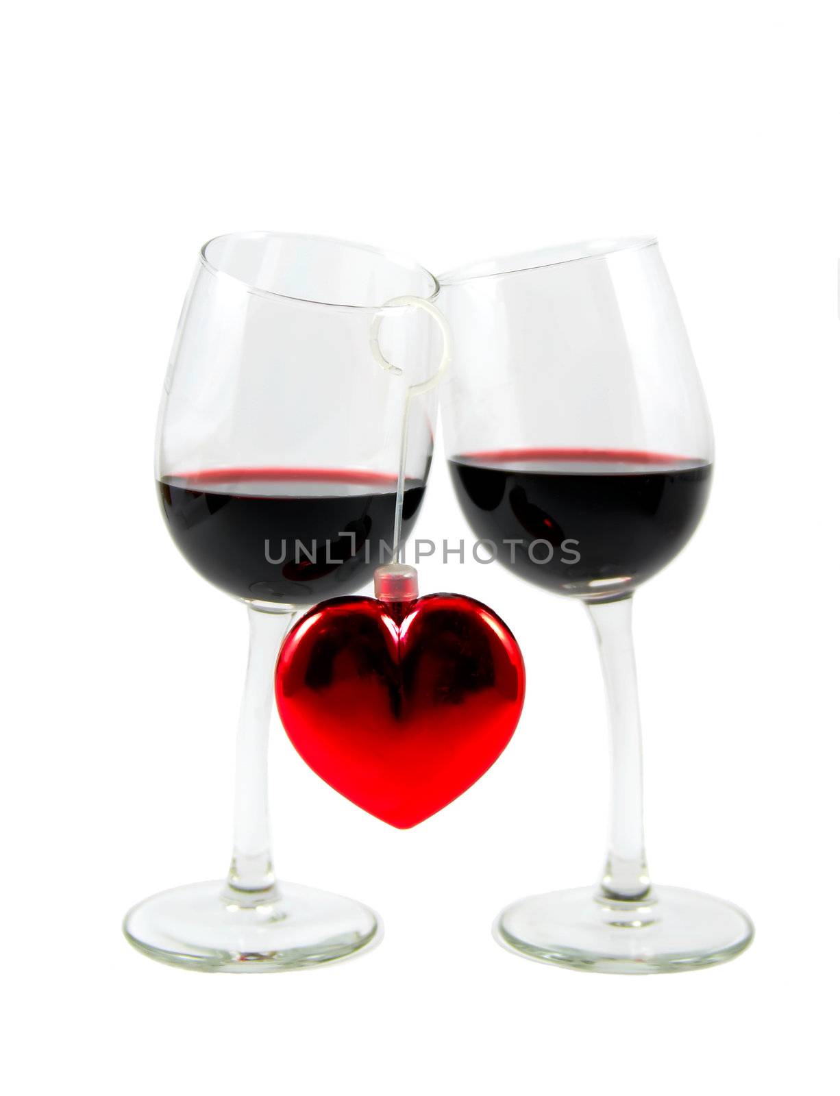 Two glasses with red wine and heart isolated over white background