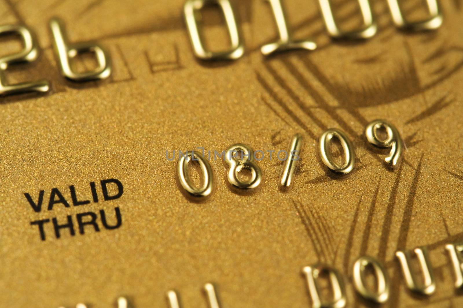Closeup of fragment of gold credit card. Very shallow depth of field, focus on number 8. 
