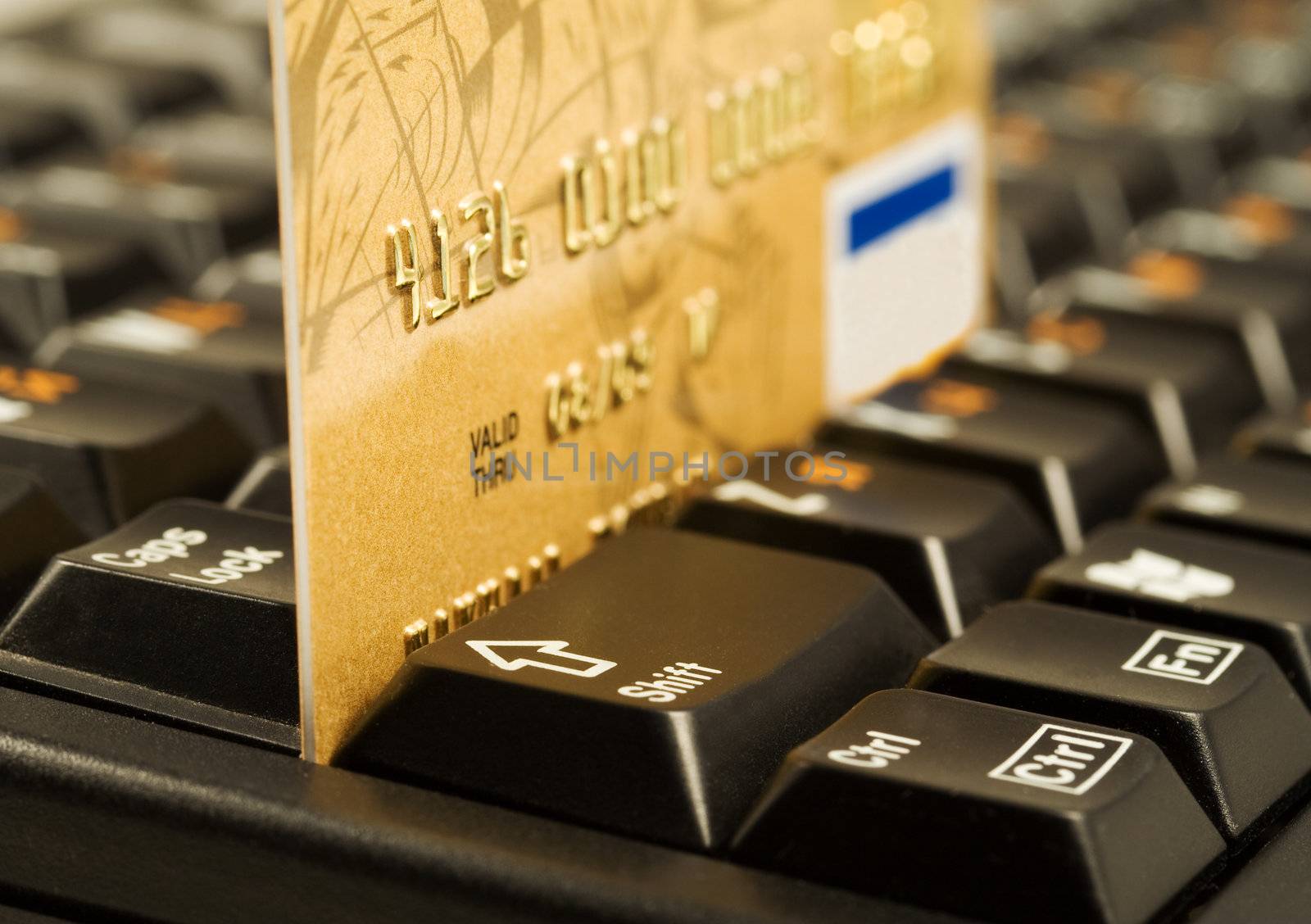 Gold credit card on computer keyboard by serpl