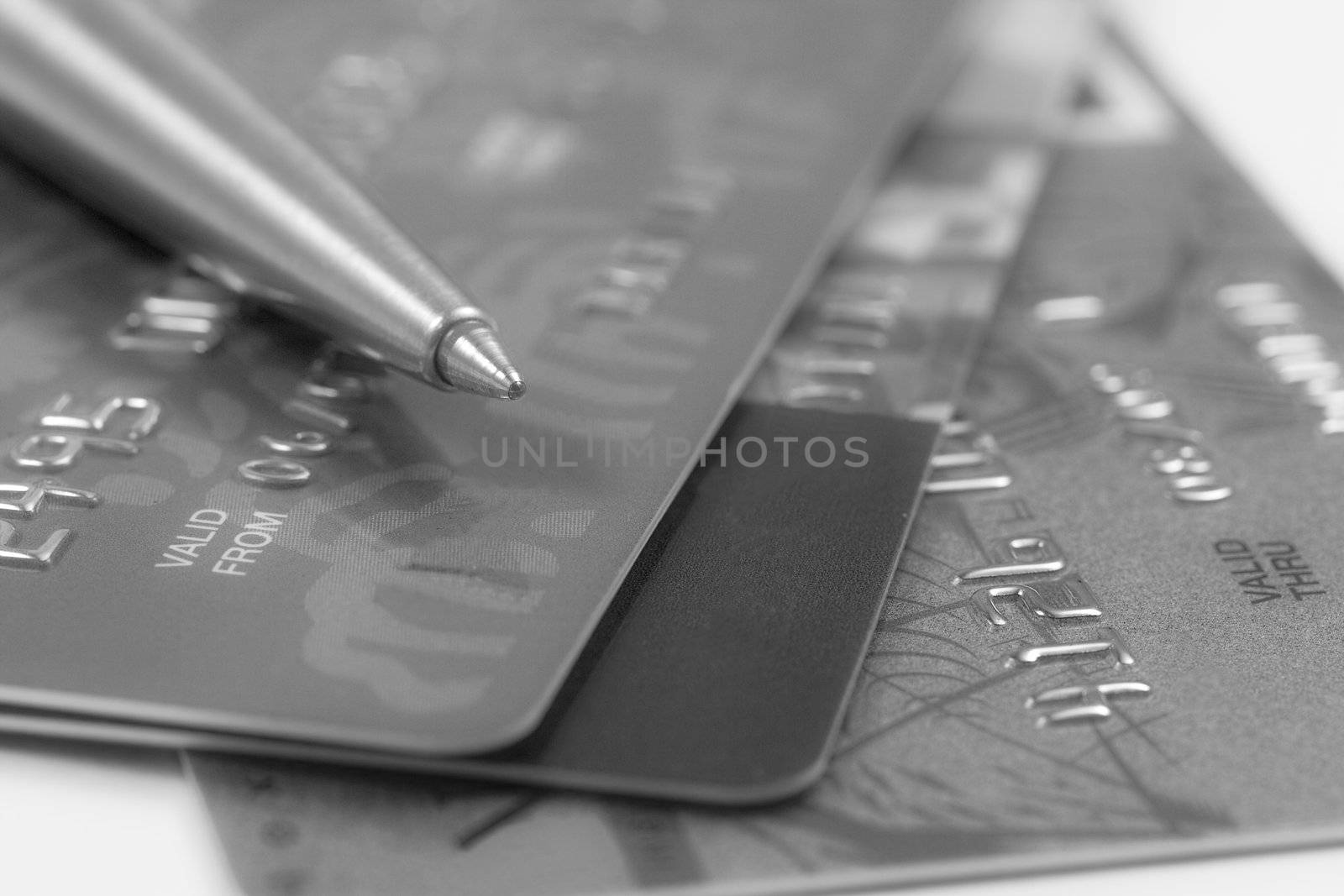 Pen on stack of credit cards. Shallow depth of field. Black and white image
