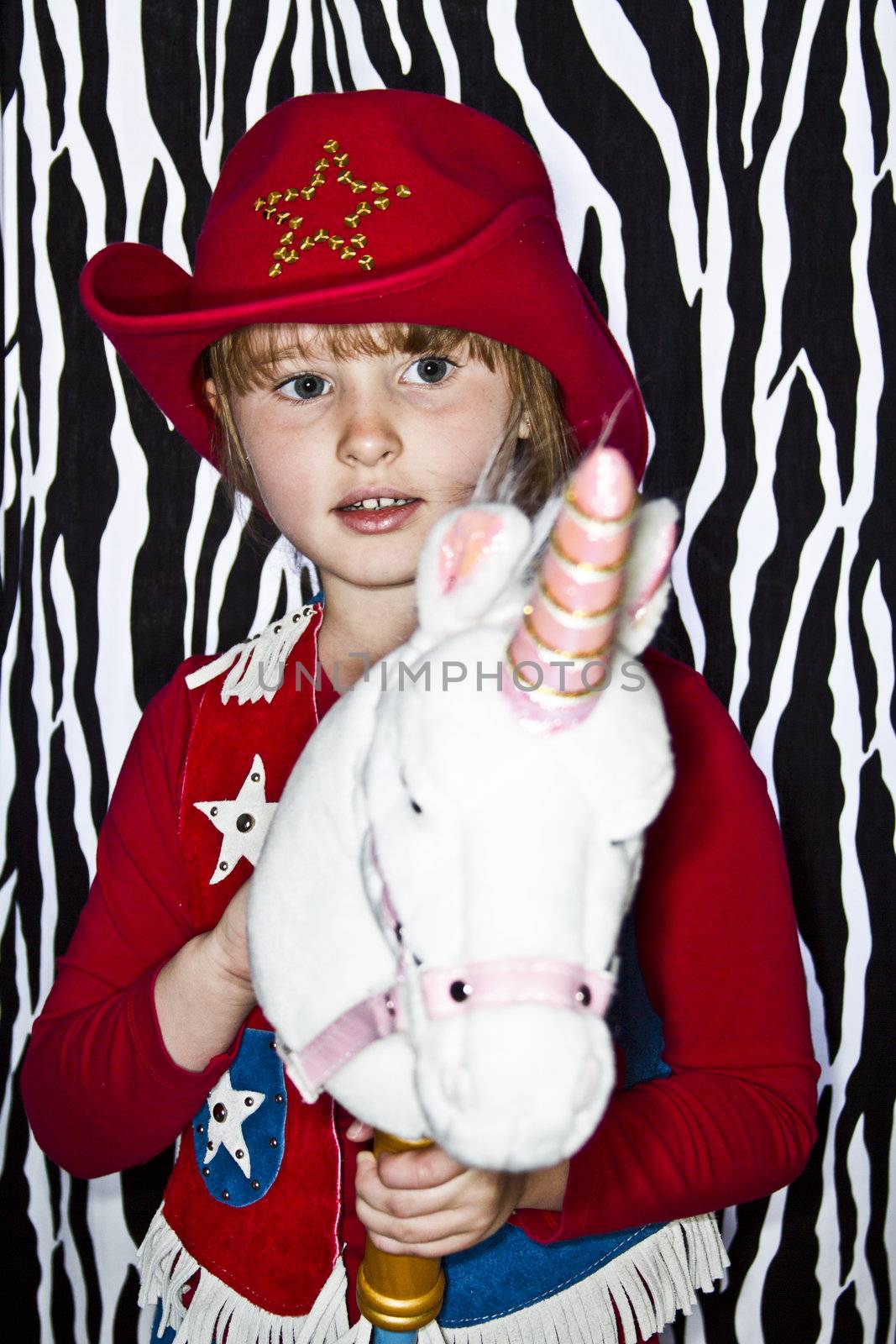 Young girl dressed up in cowgirl outfit.