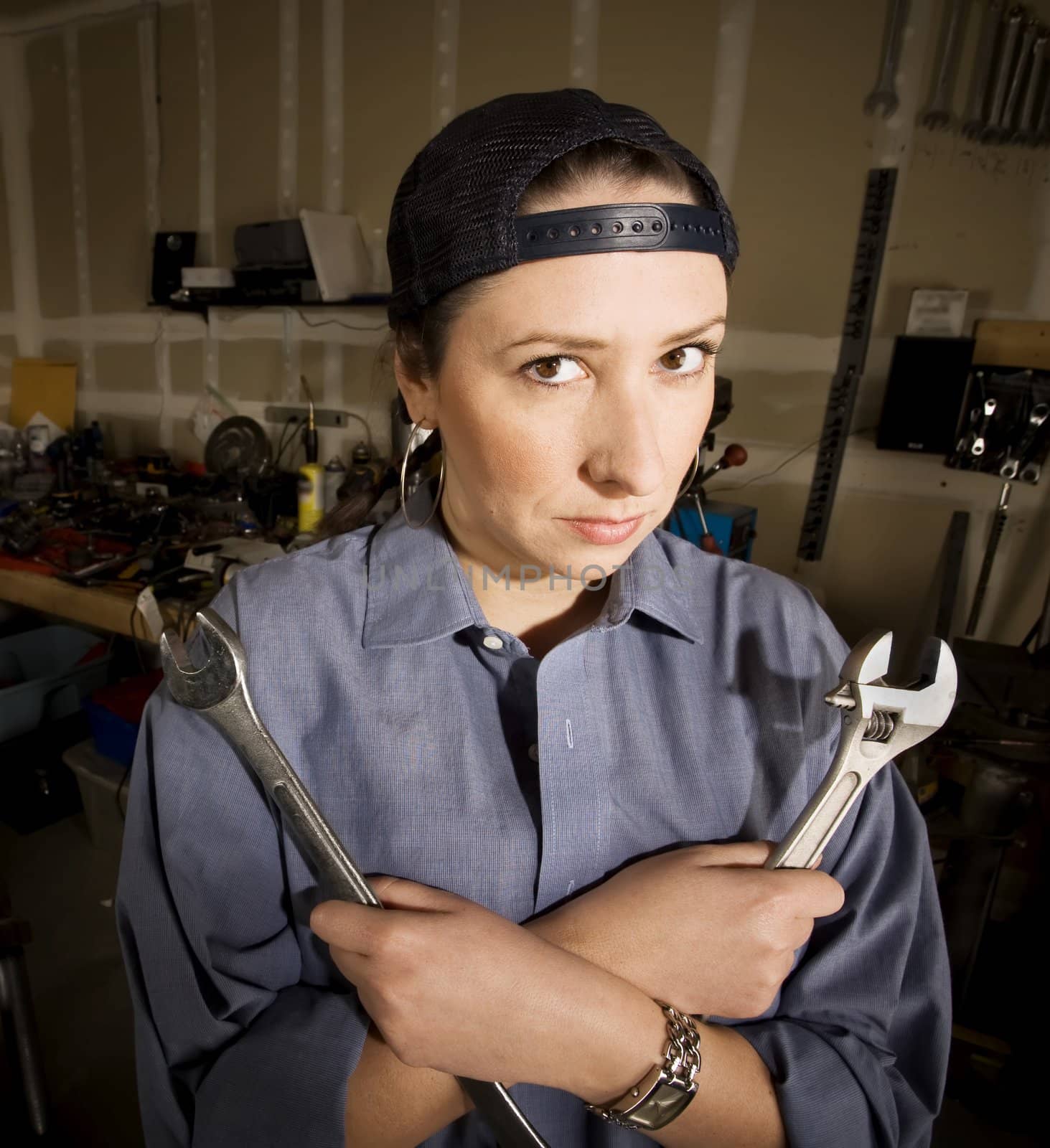 Hispanic woman in a garage with wrenches
