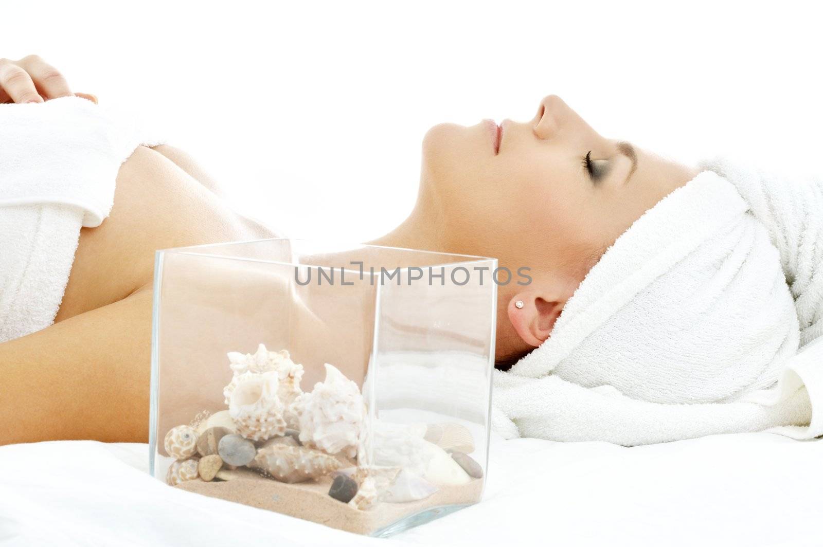 beautiful lady in spa salon with sea shells in glass cube