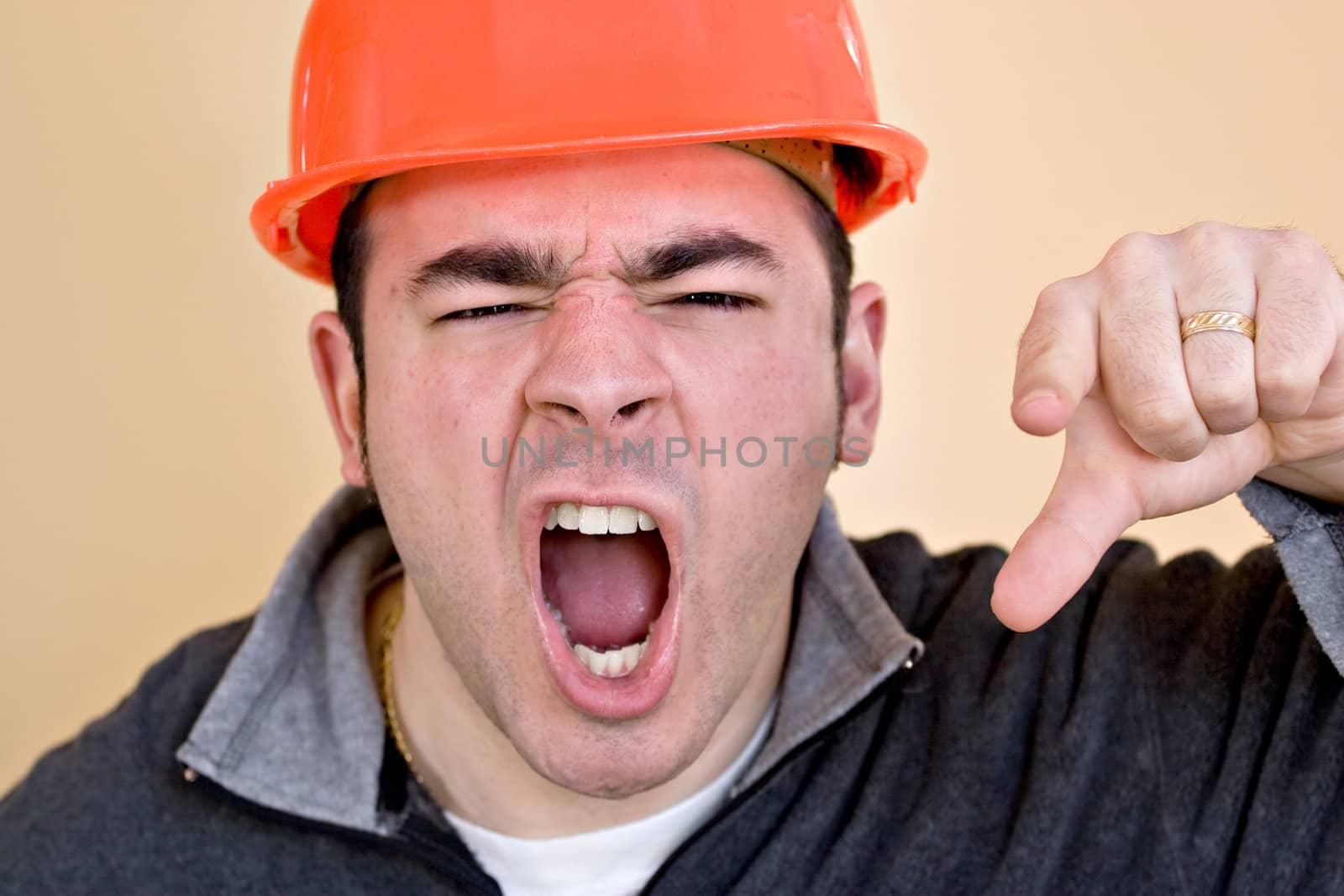 This construction worker is pointing and yelling his head off at someone.