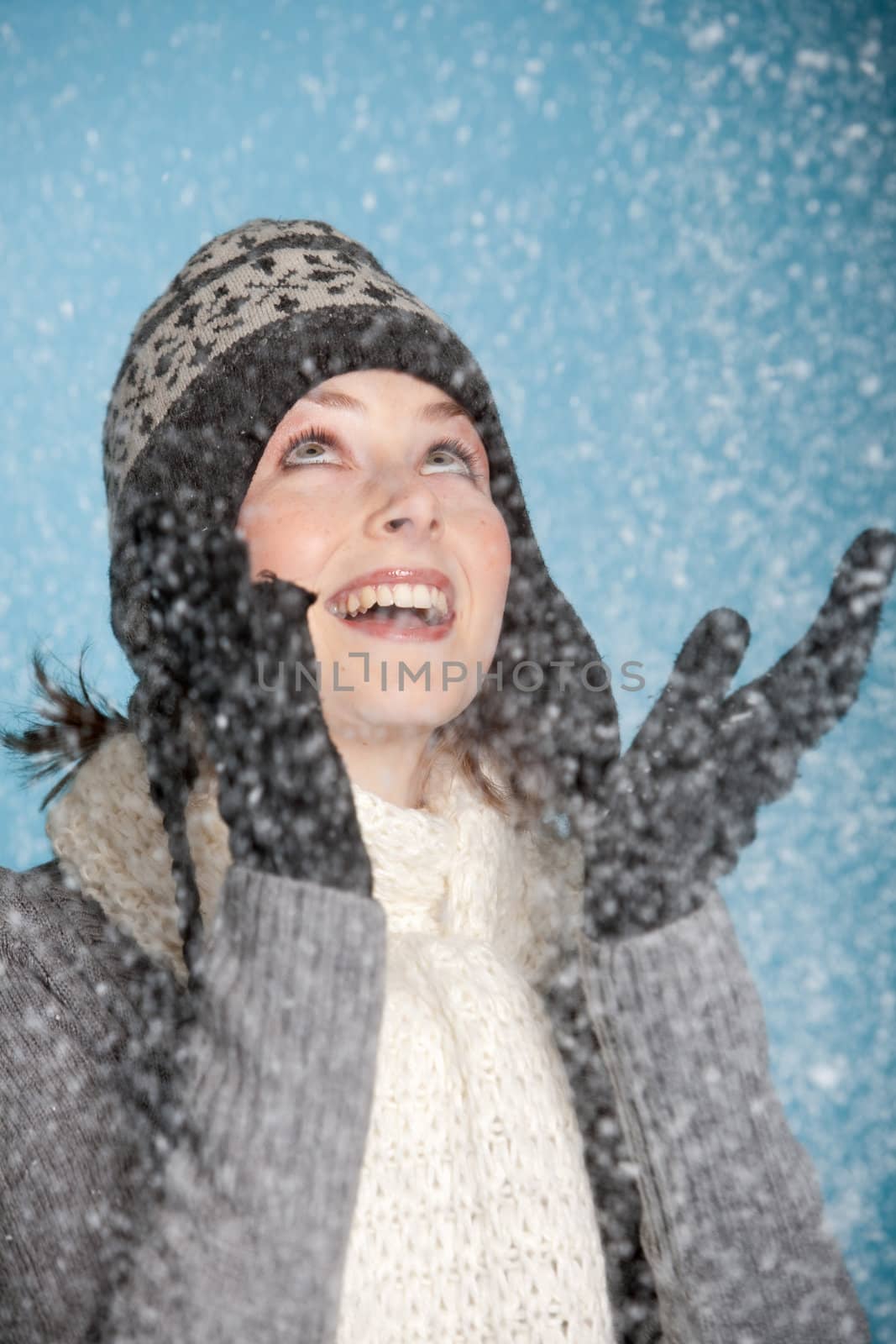 Pretty girl with warm winter clothes standing in the snow