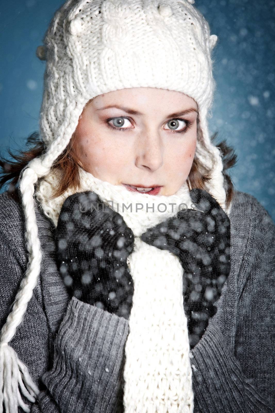 Beautiful girl with warm winterclothes in the snow