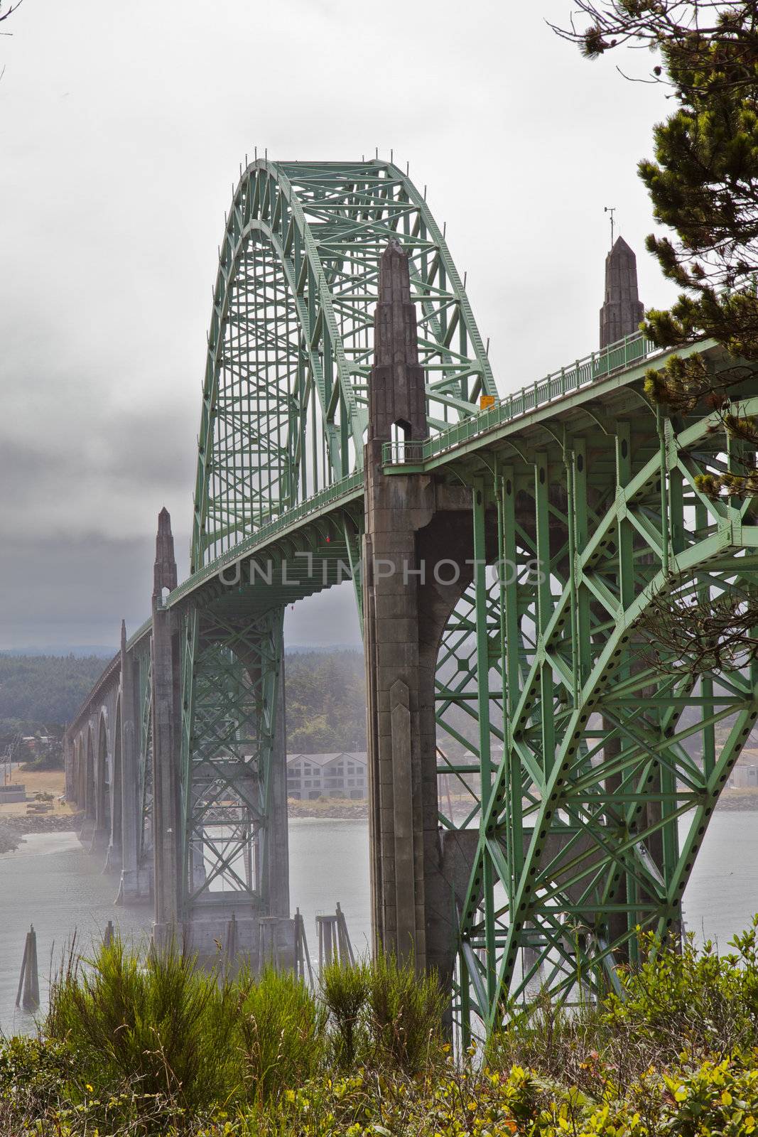 Old green metal bridge disappearing into the mist