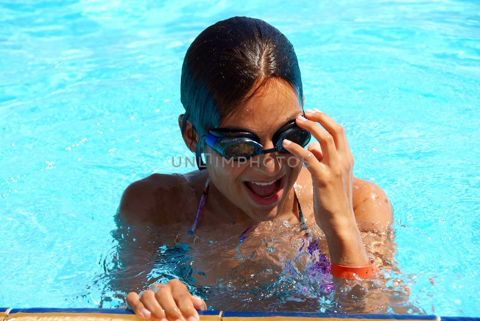 happy teen girl in blue swimming pool portrait