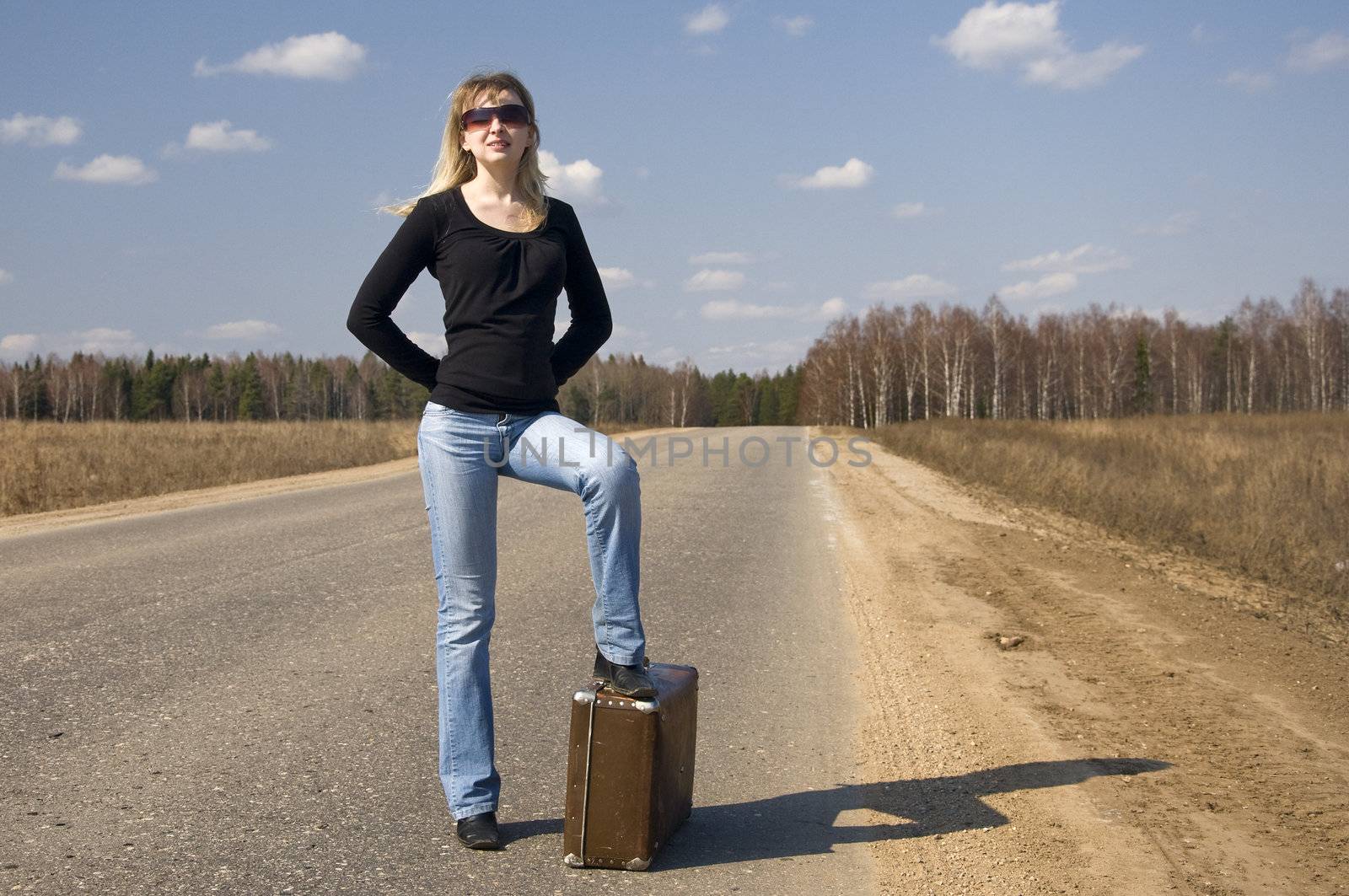 pretty girl waiting on the road with her baggage