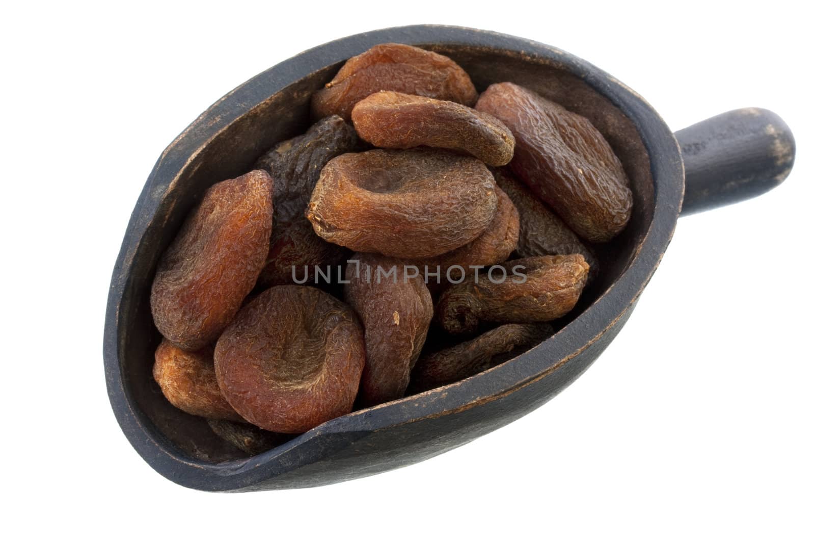 dried Turkish apricots on a rustic, wooden scoop, isolated on white