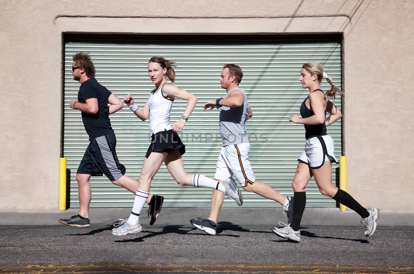 Foursome runs in the city for exercise. by Creatista