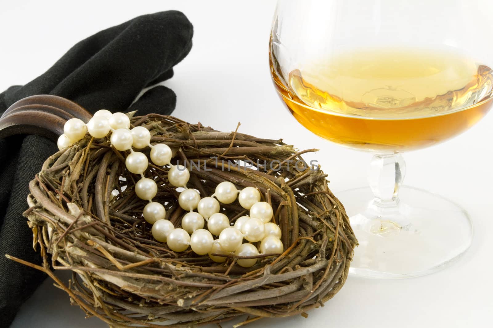 A feminine nest egg of pearls presented with a glass of brandy