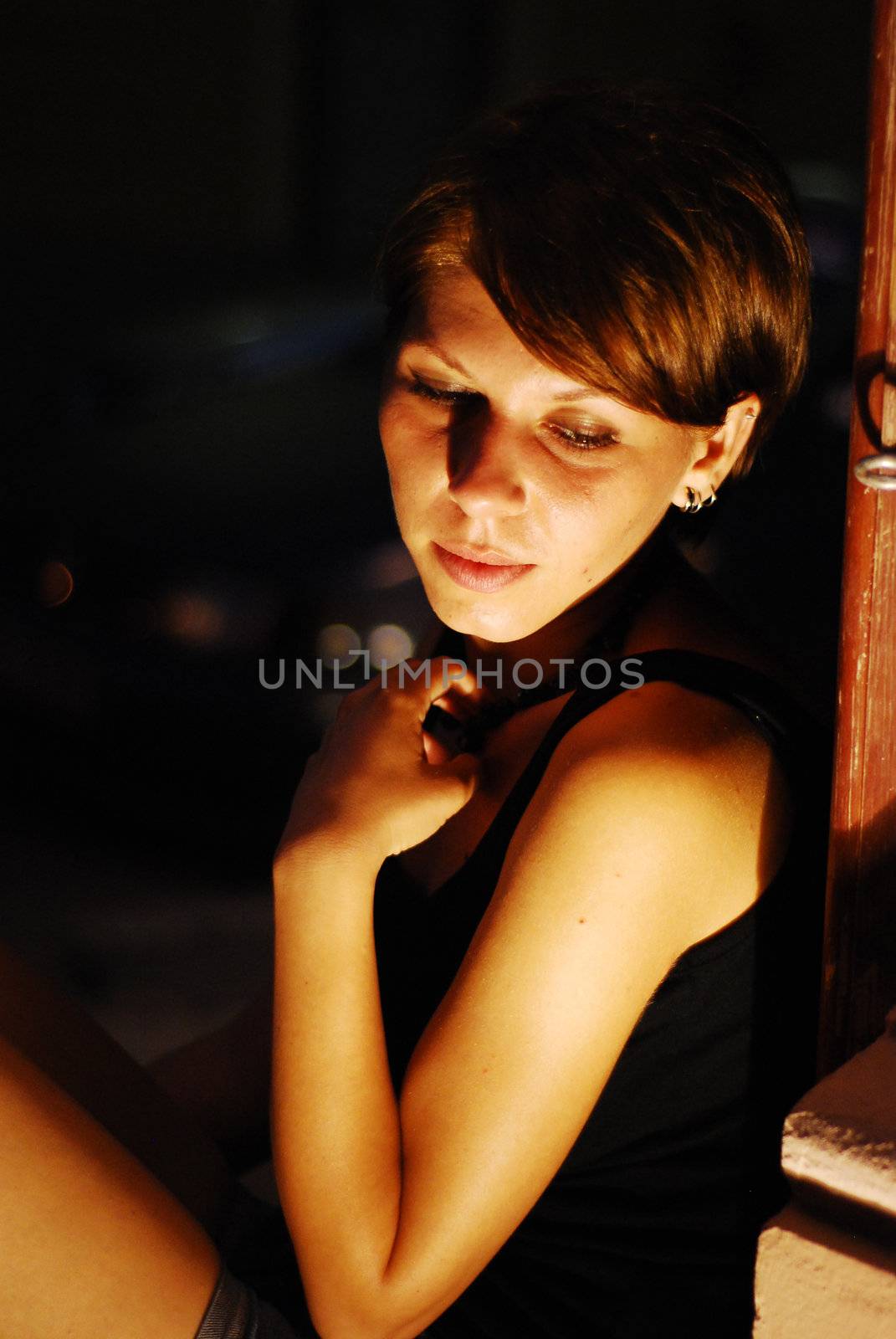 Young pretty girl in front of an yellow spotlight posing