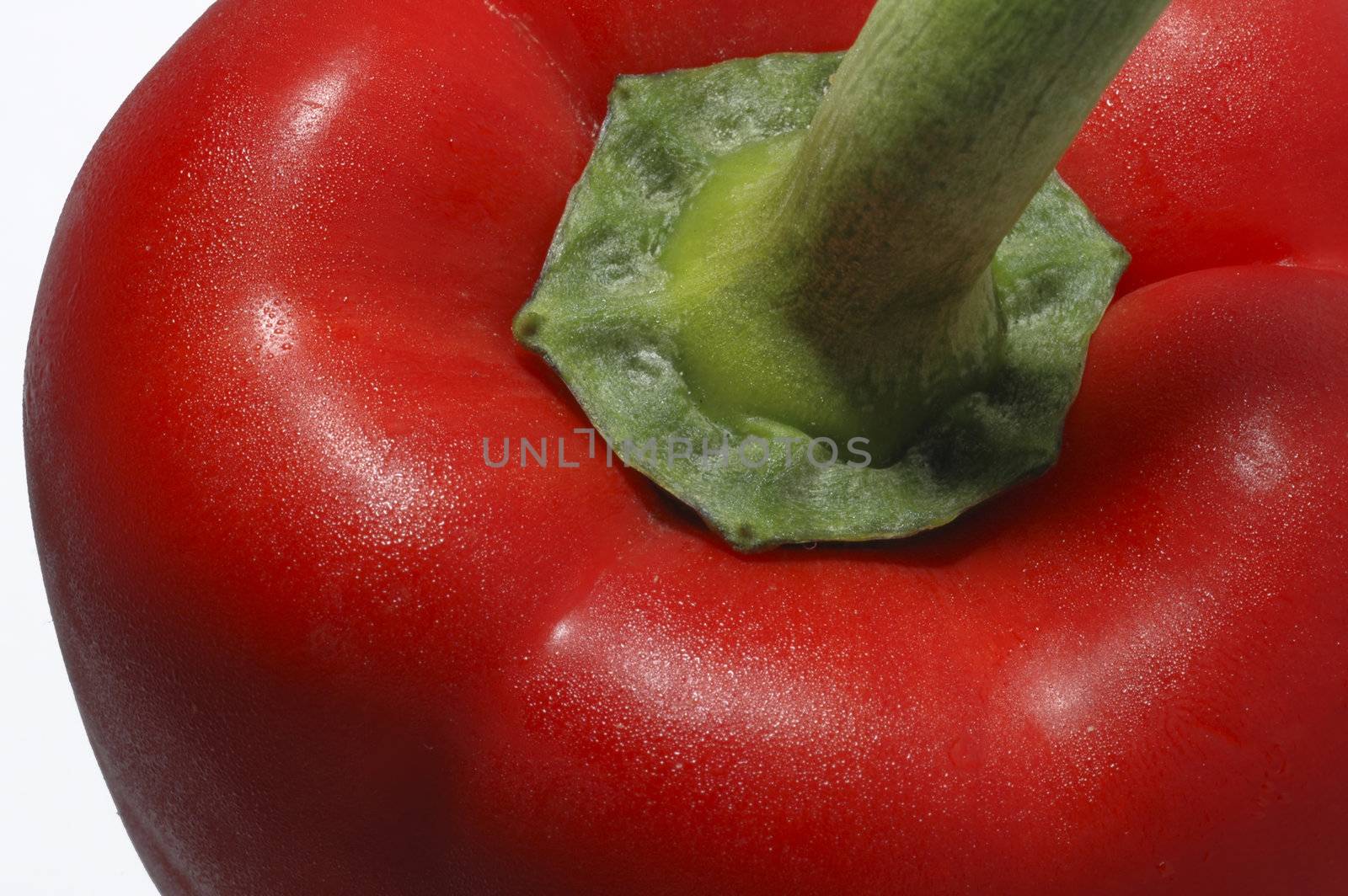 A close up of a red pepper with water mist