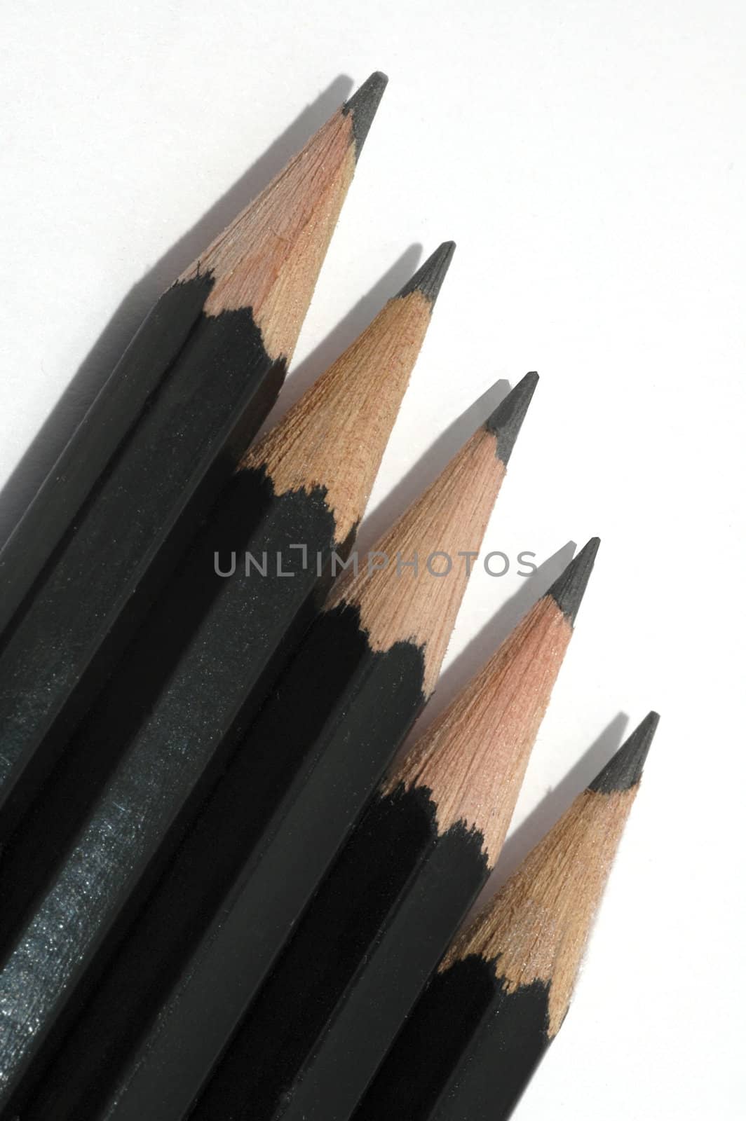 A row of 5 artist's drawing pencils