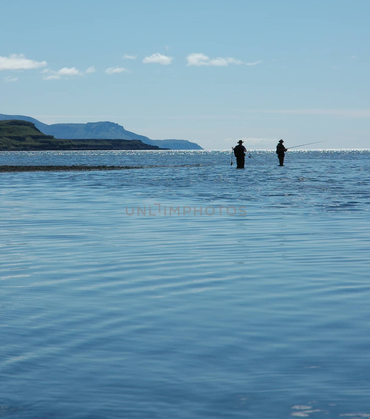 Two people fishing with rods in the sea
