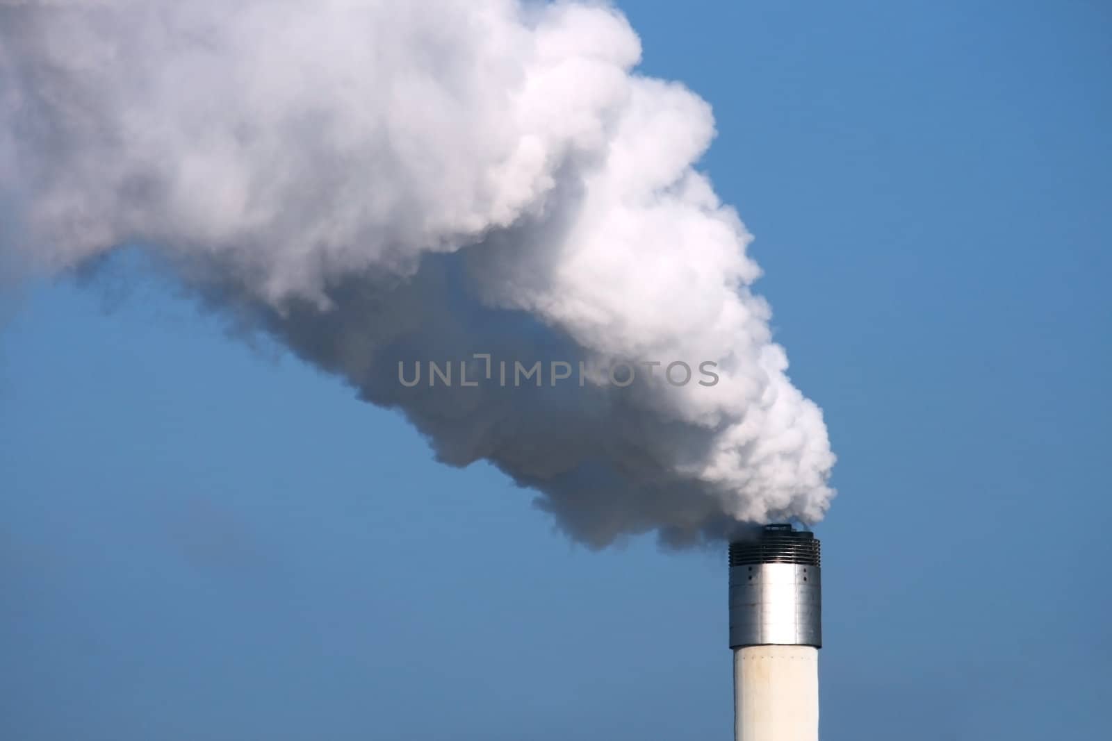 chimney with smoke on with blue sky