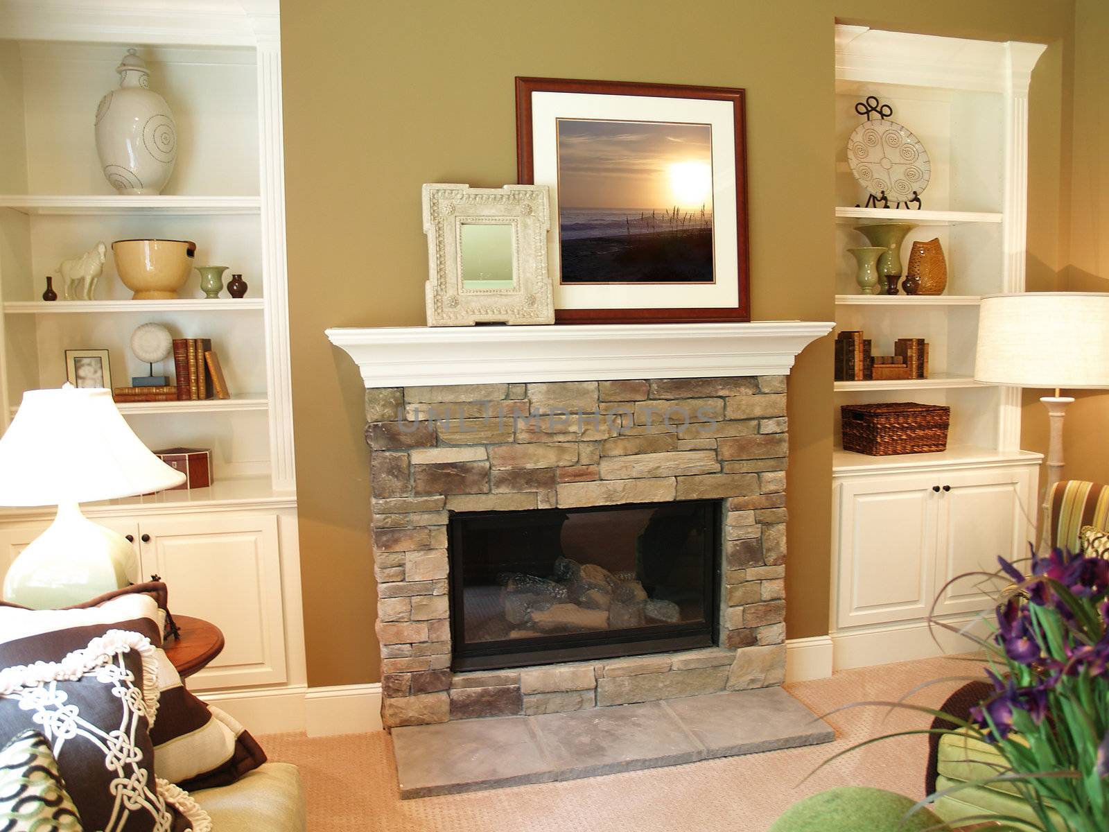 Stone fireplace in a modern living room with a white painted wooden mantle. Artwork has been replaced with art that I own the copyright to. 