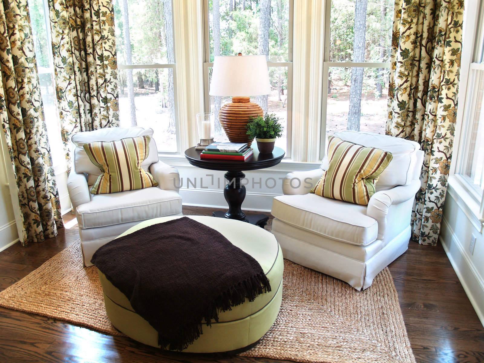 Two comfortable overstuffed chairs in a nicely decorated luxury sunroom