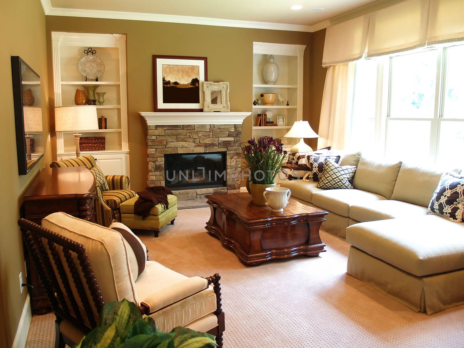 A well furnished family room with a stone fireplace lit by the sunlight