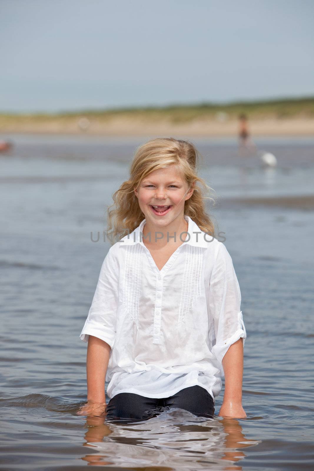 Cute young child looking very happy while sitting in the water