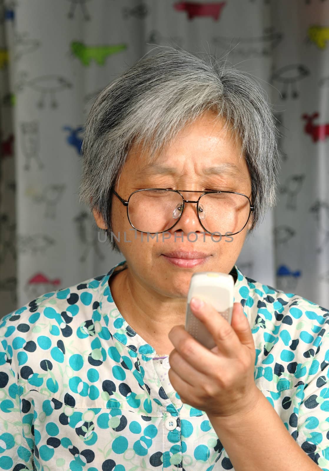 middleage woman looking on phone by leungchopan