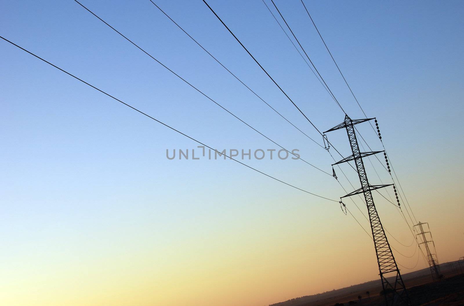 Power supply : electrical pylons and wires on sunset background