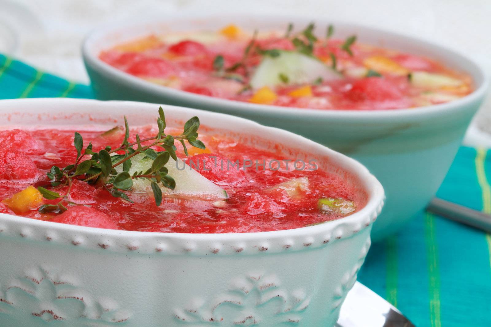 Watermelon Gazpacho made with watermelon, yellow peppers, cucumber, and garnished with a sprig of fresh thyme.