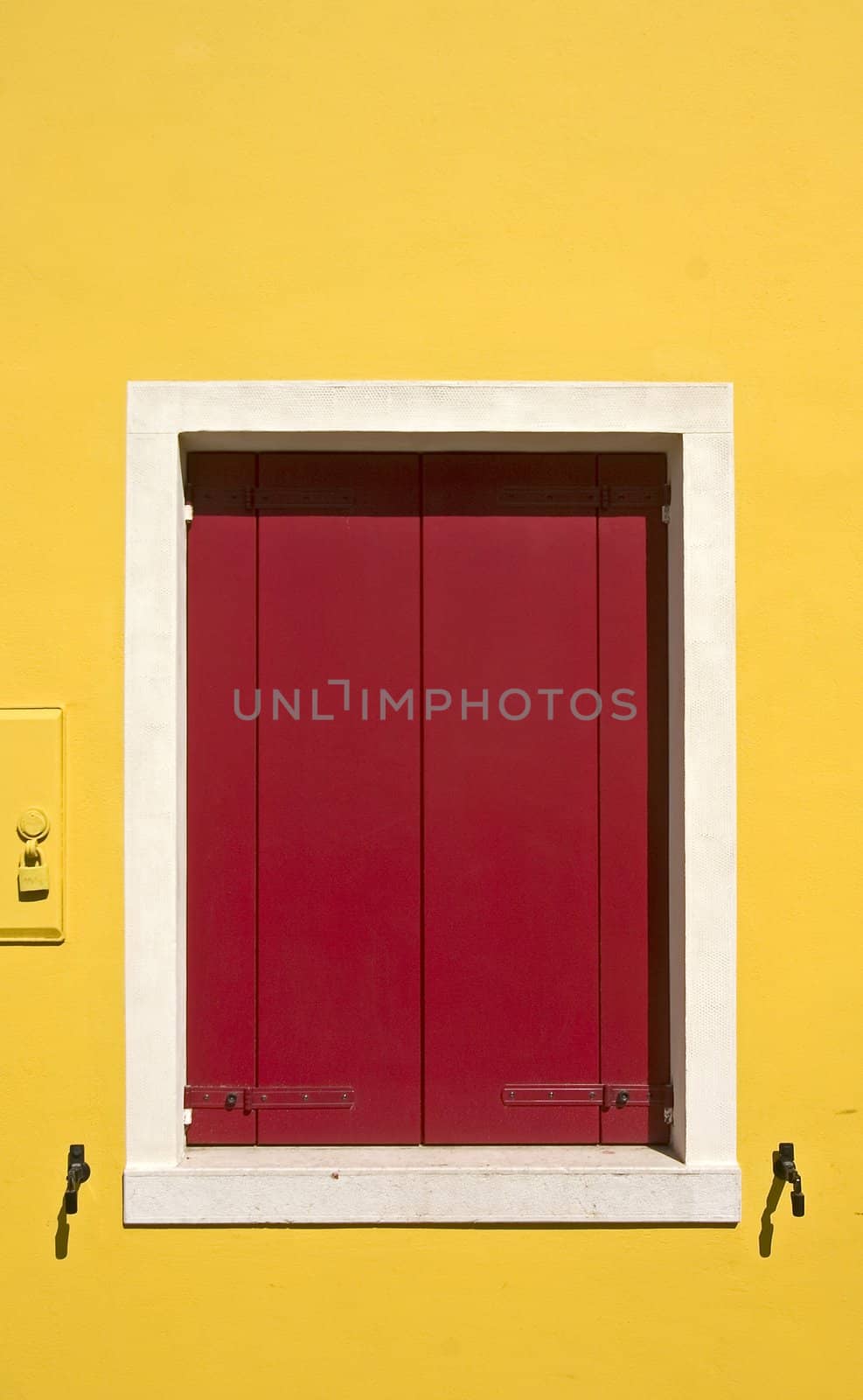 yellow wall with a red window-shutters