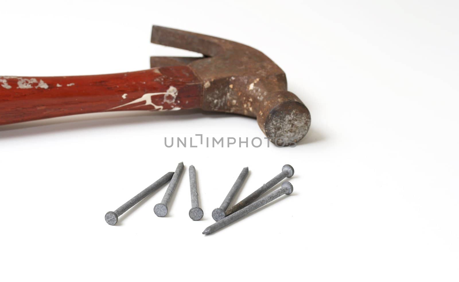 a macro picture of a hammer and nails on white