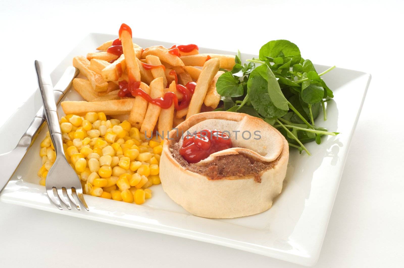 Homemade beef meat pie with fries and vegetables.