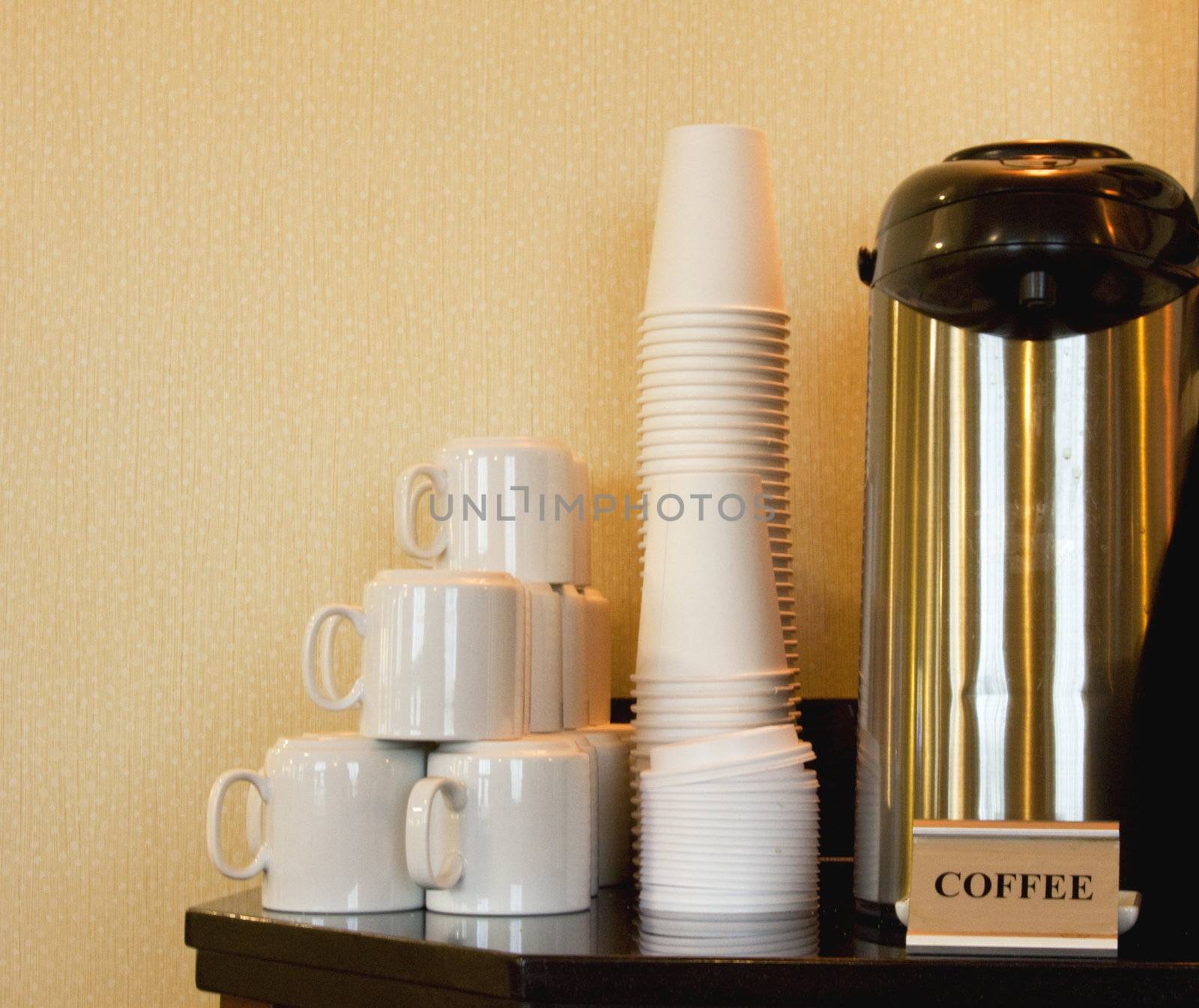 Coffee station equipped with ceramic mugs and paper cups for quick, caffeinated refreshment