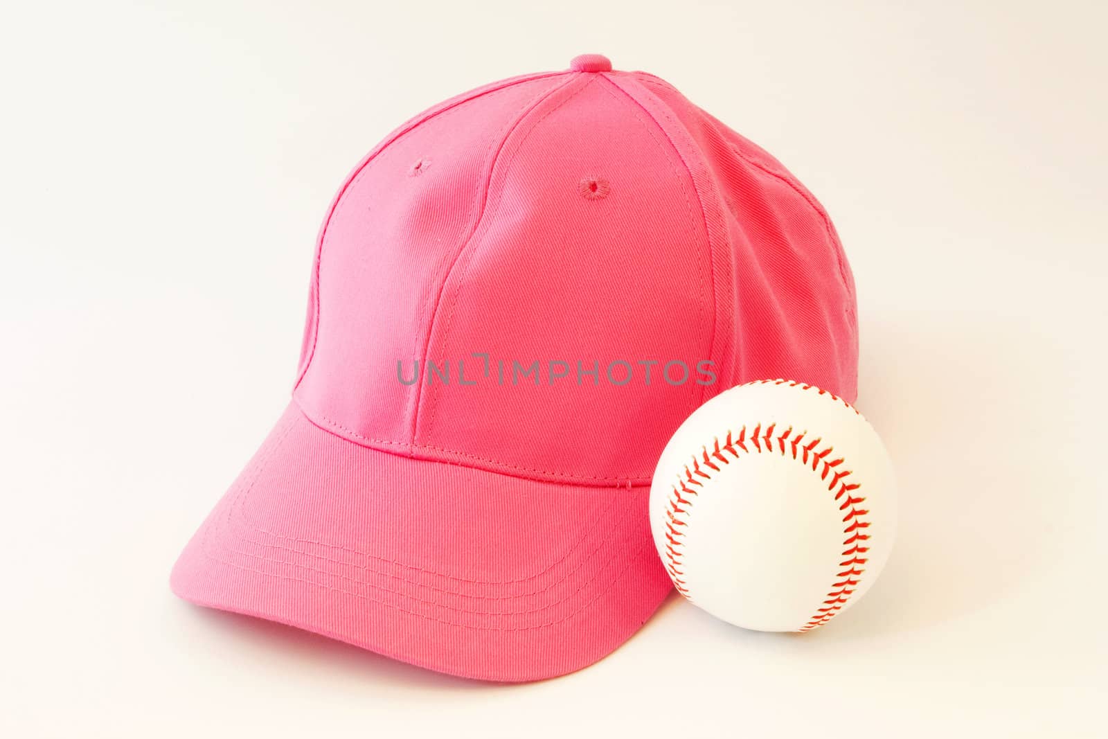 Pink baseball cap next to baseball reflects a feminist involvement in our national pastime;