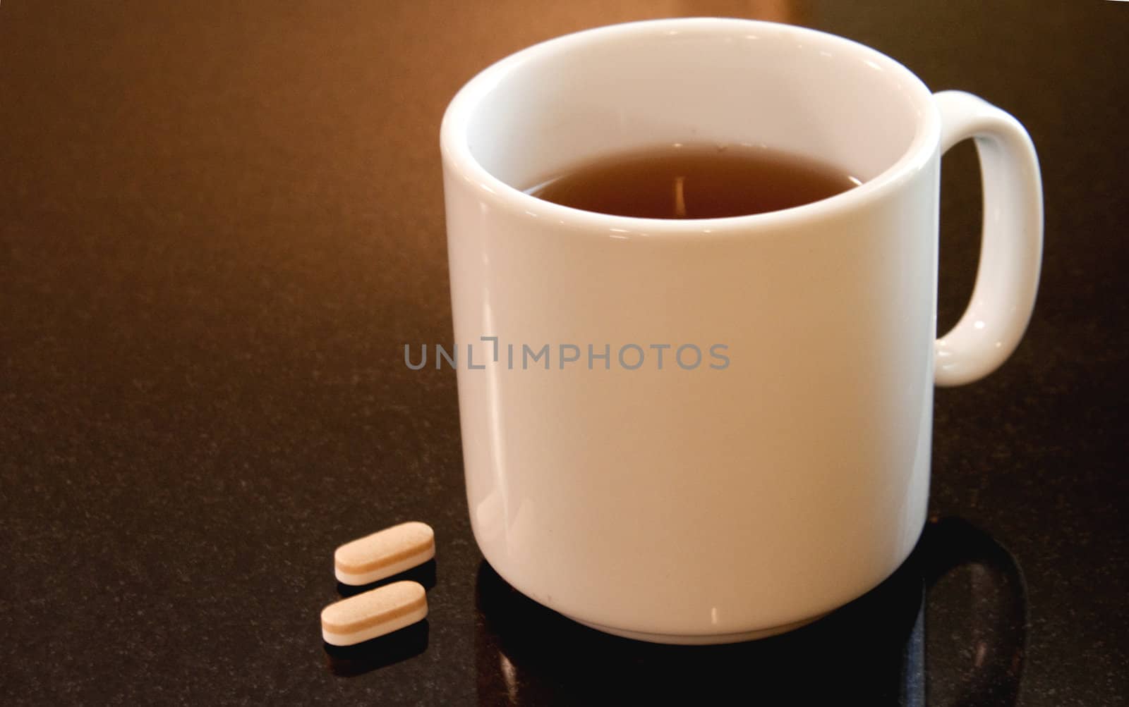 Two pills and mug of coffee suggest a medicinal routine