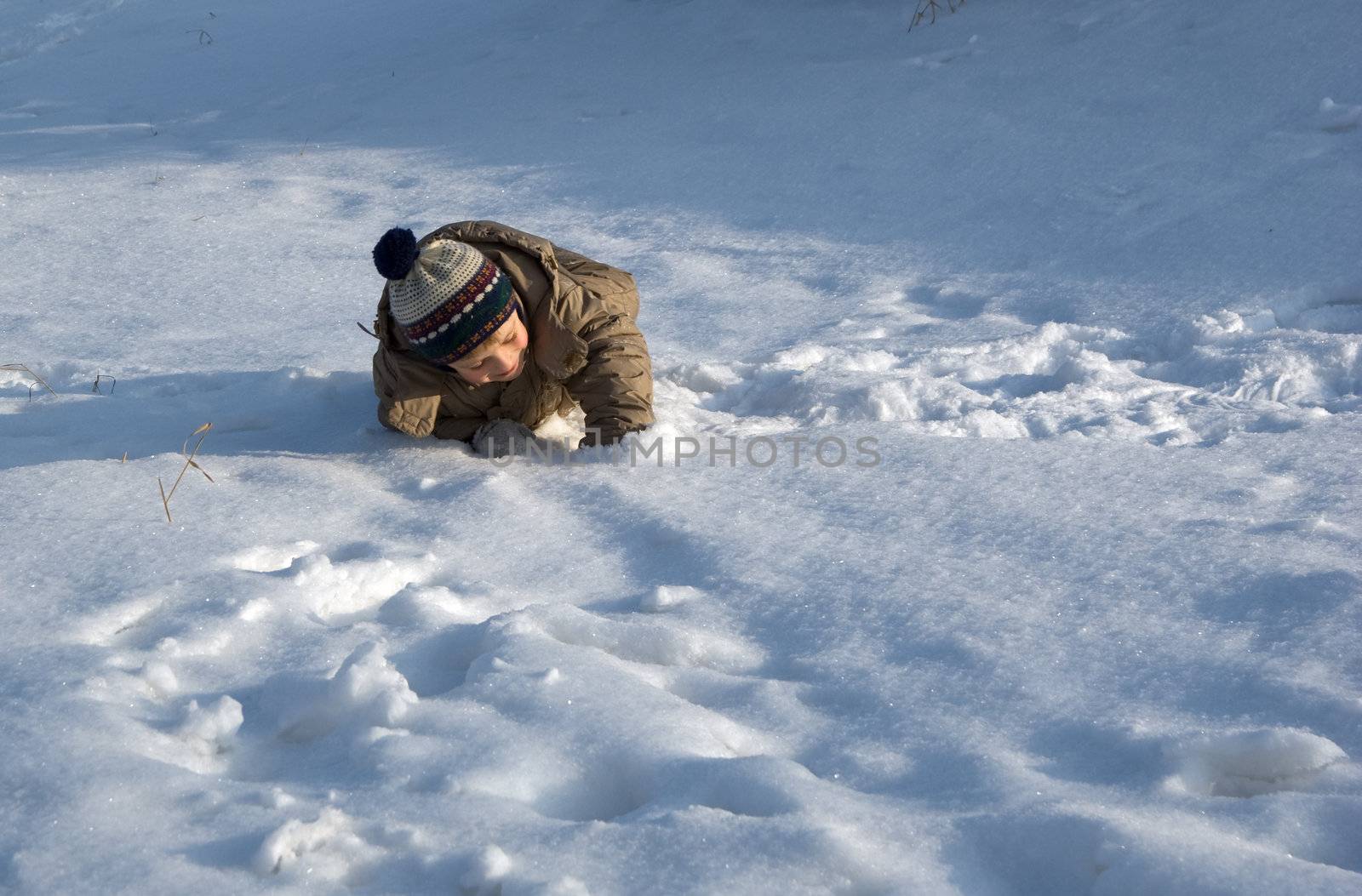 The small child goes for a drive on a snow field