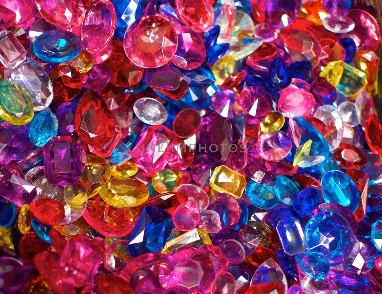 A field of brightly colored plastic jewels which are pink, red, blue and yellow in color