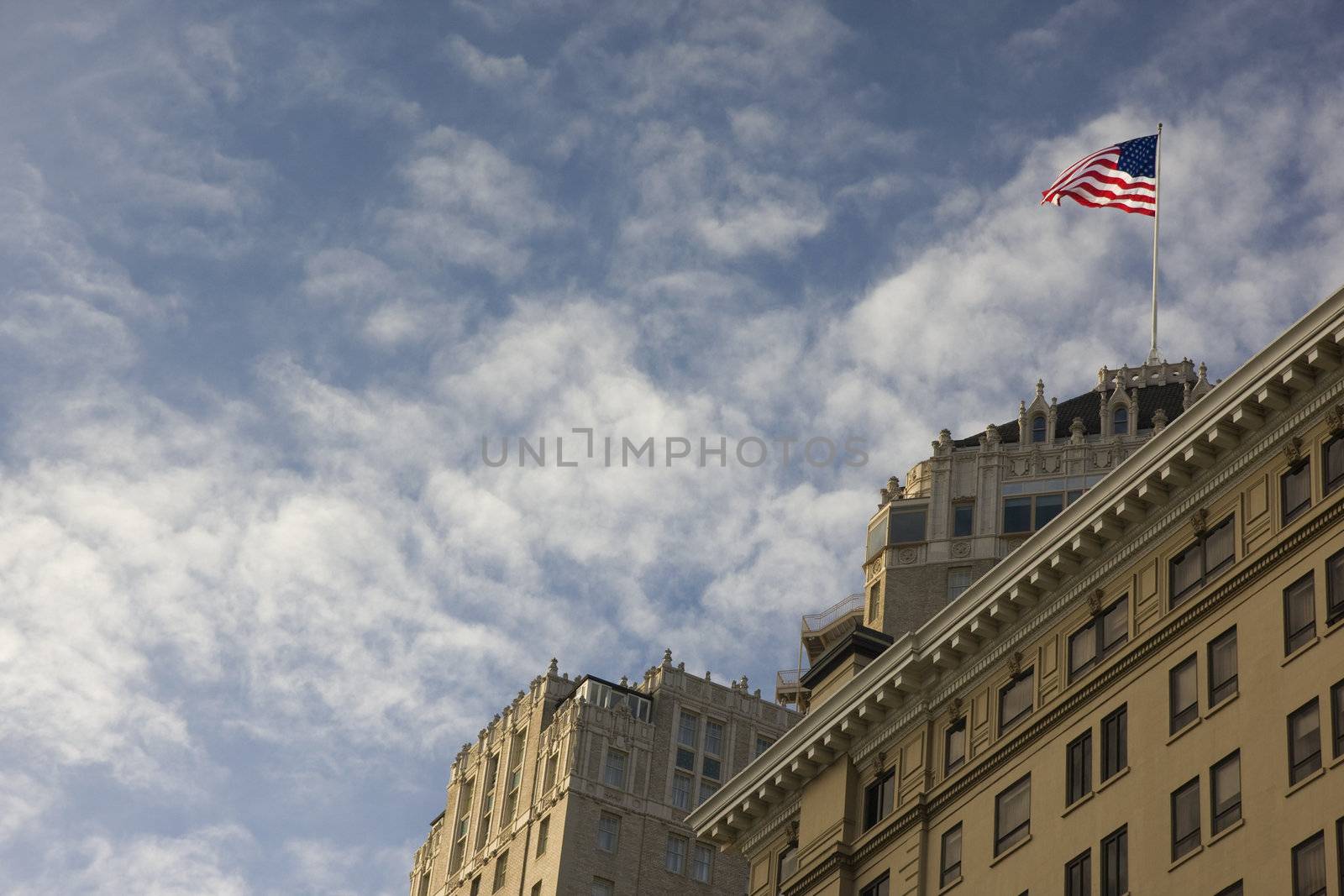 American flag on a building roof by PixelsAway