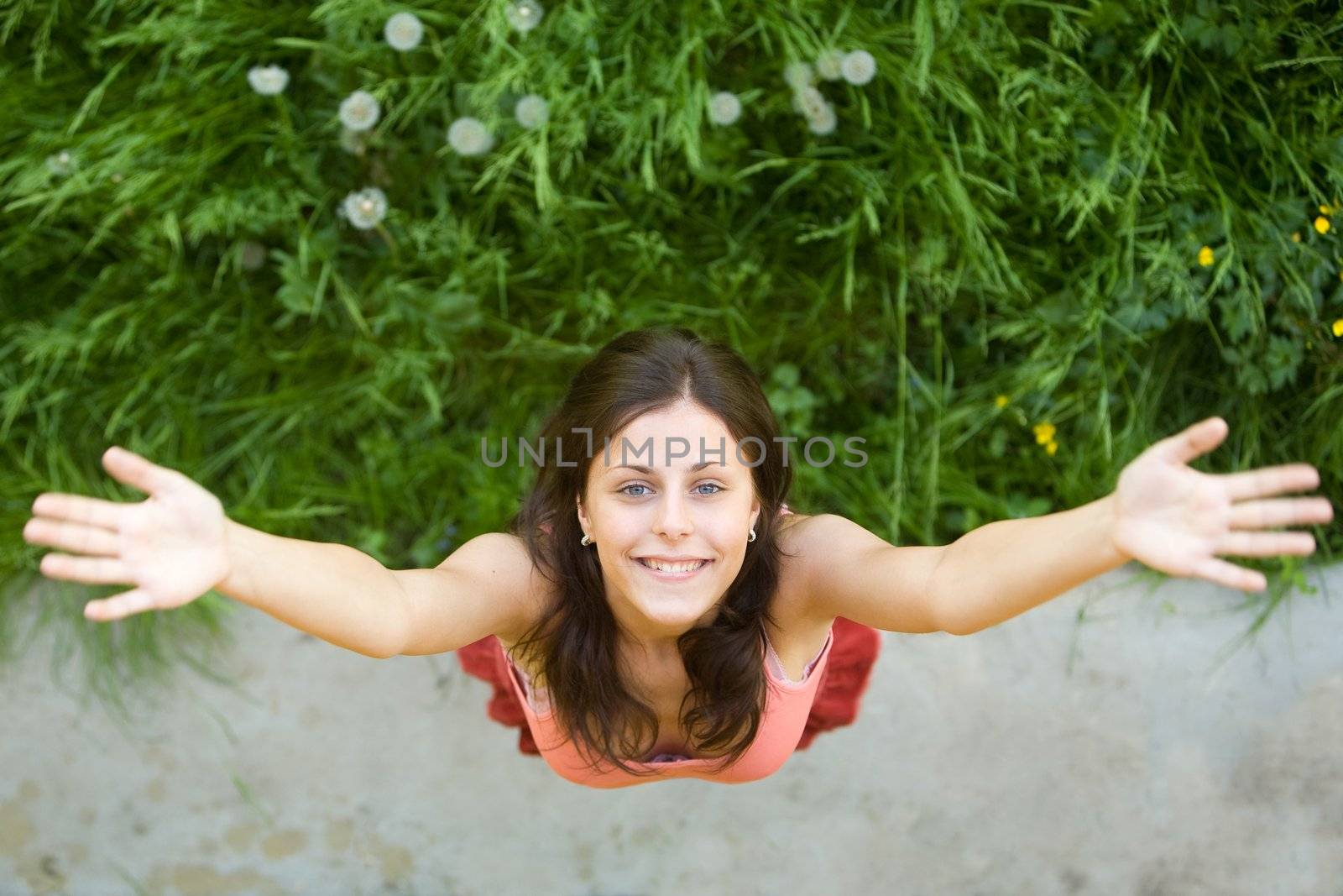 The girl with a happy smile on a green grass 
