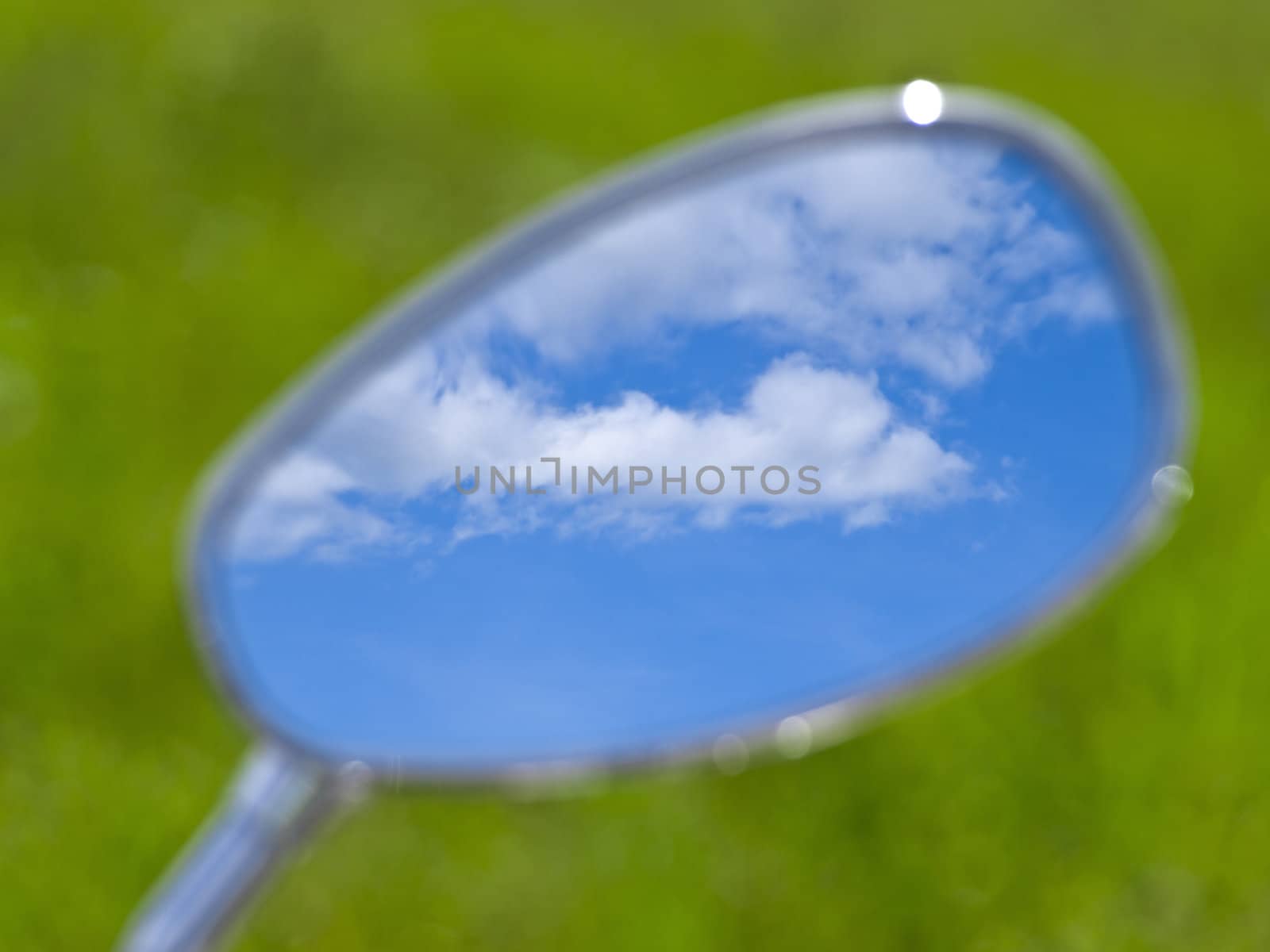 blue cloudy sky reflection in the motorcycle mirror