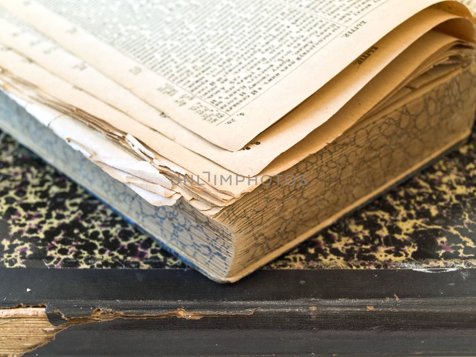 Old open book with closed book at the white table