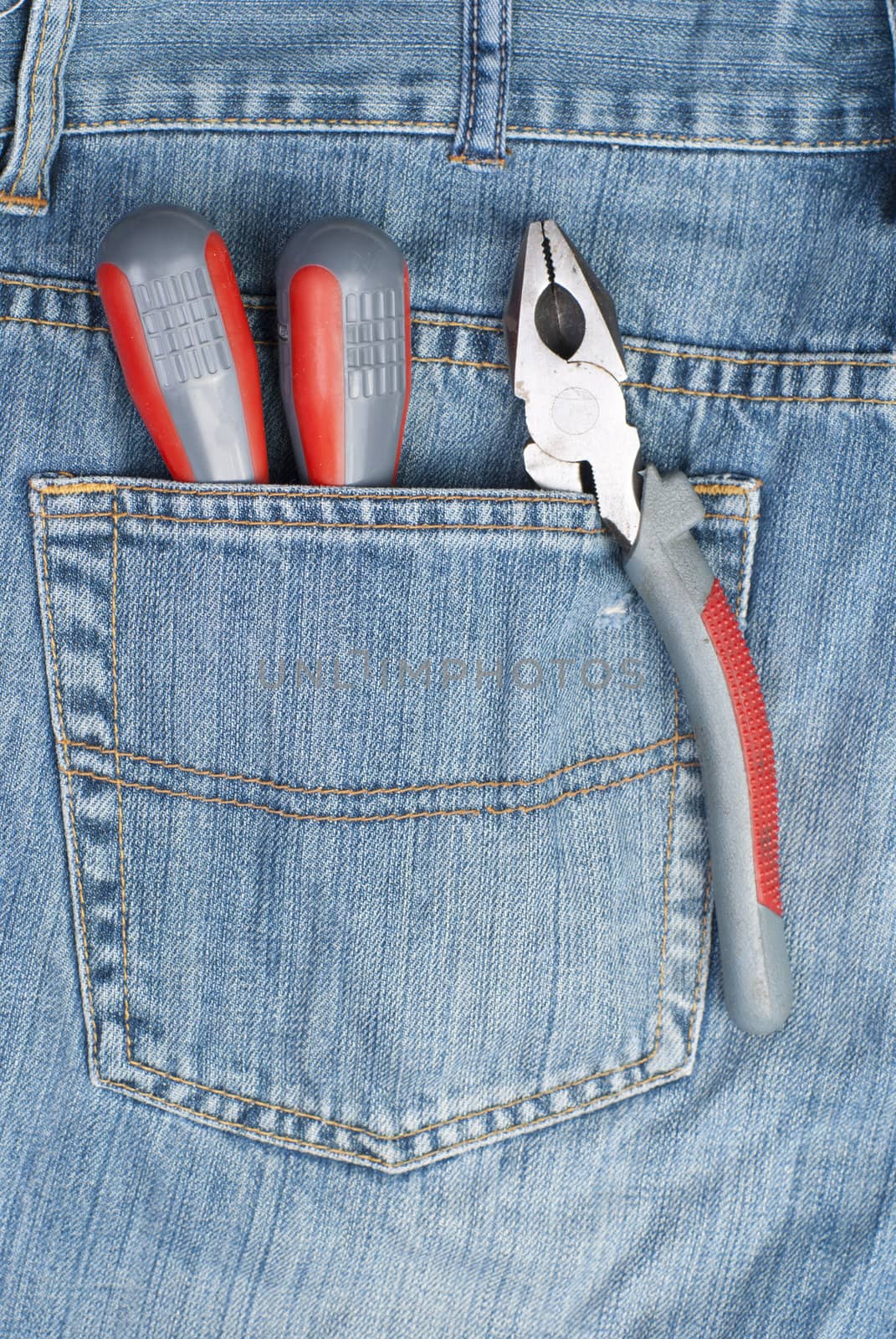 two screwdriver and pliers in the pocket of jeans