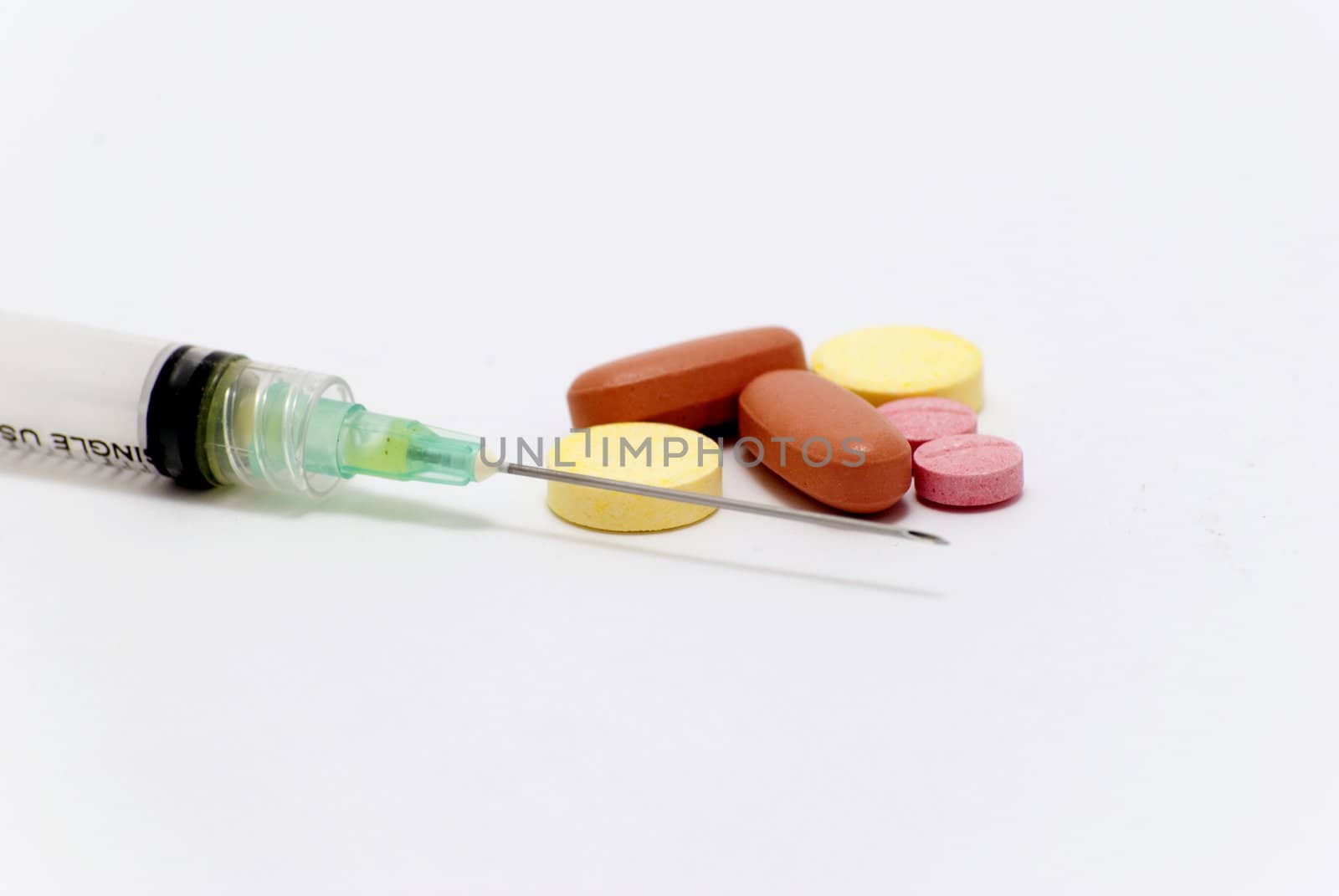 syringe and pills on white background