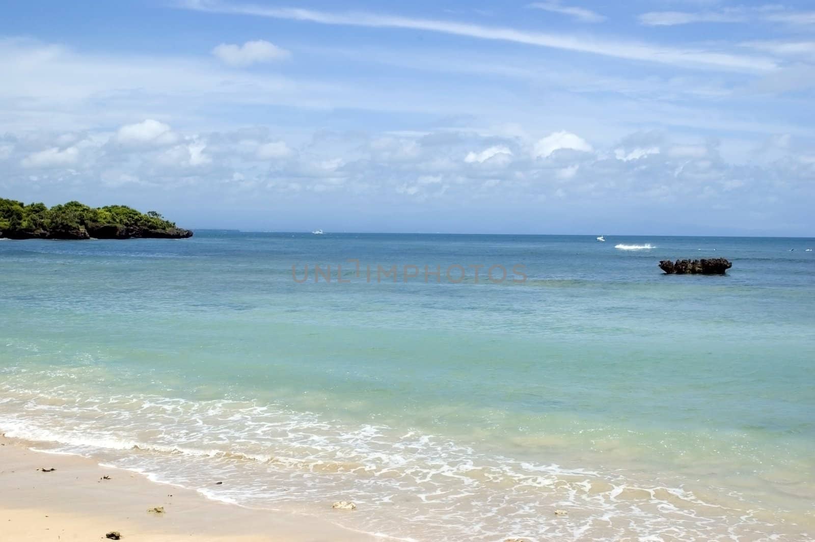 Indonesia, Bali Island, holiday resort in NusaDua. Beautiful beach with green palms and blue ocean water.