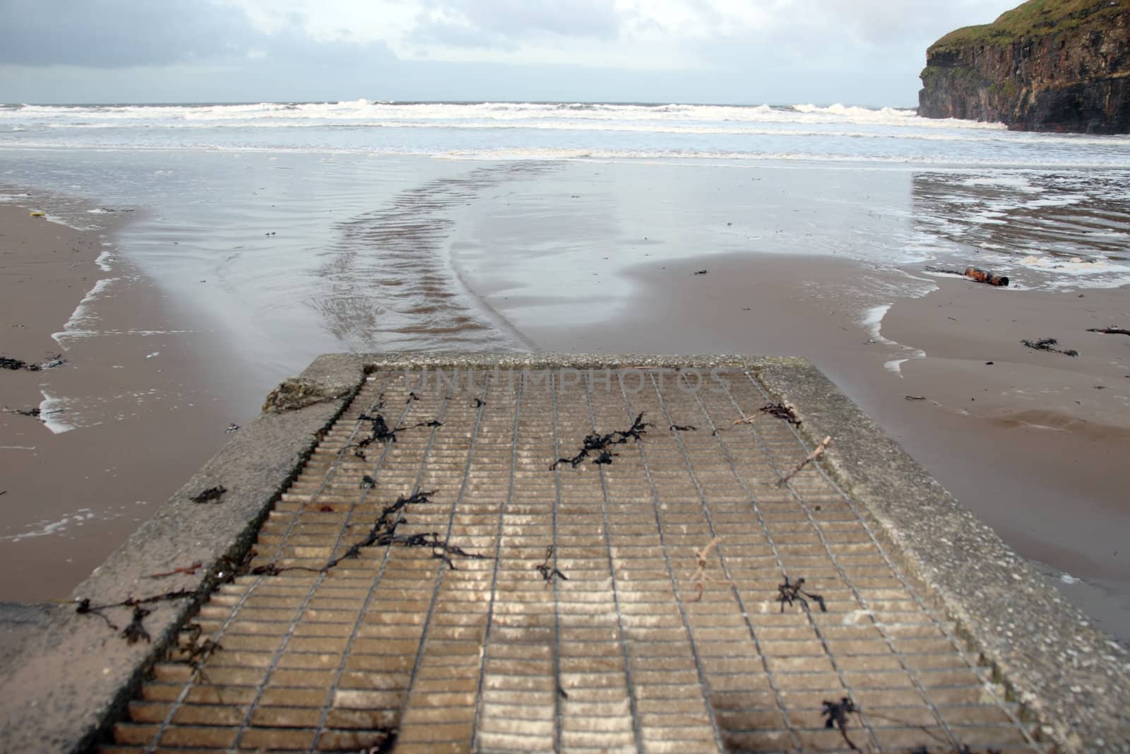 a storm drain on a beautiful beach