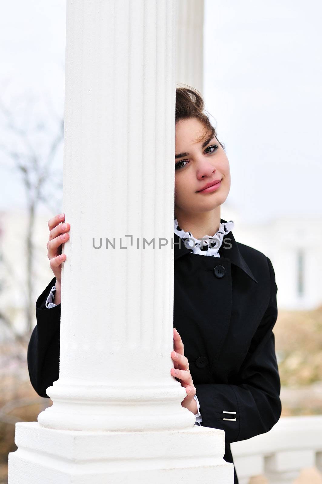 teen beautiful girl standing behind white column