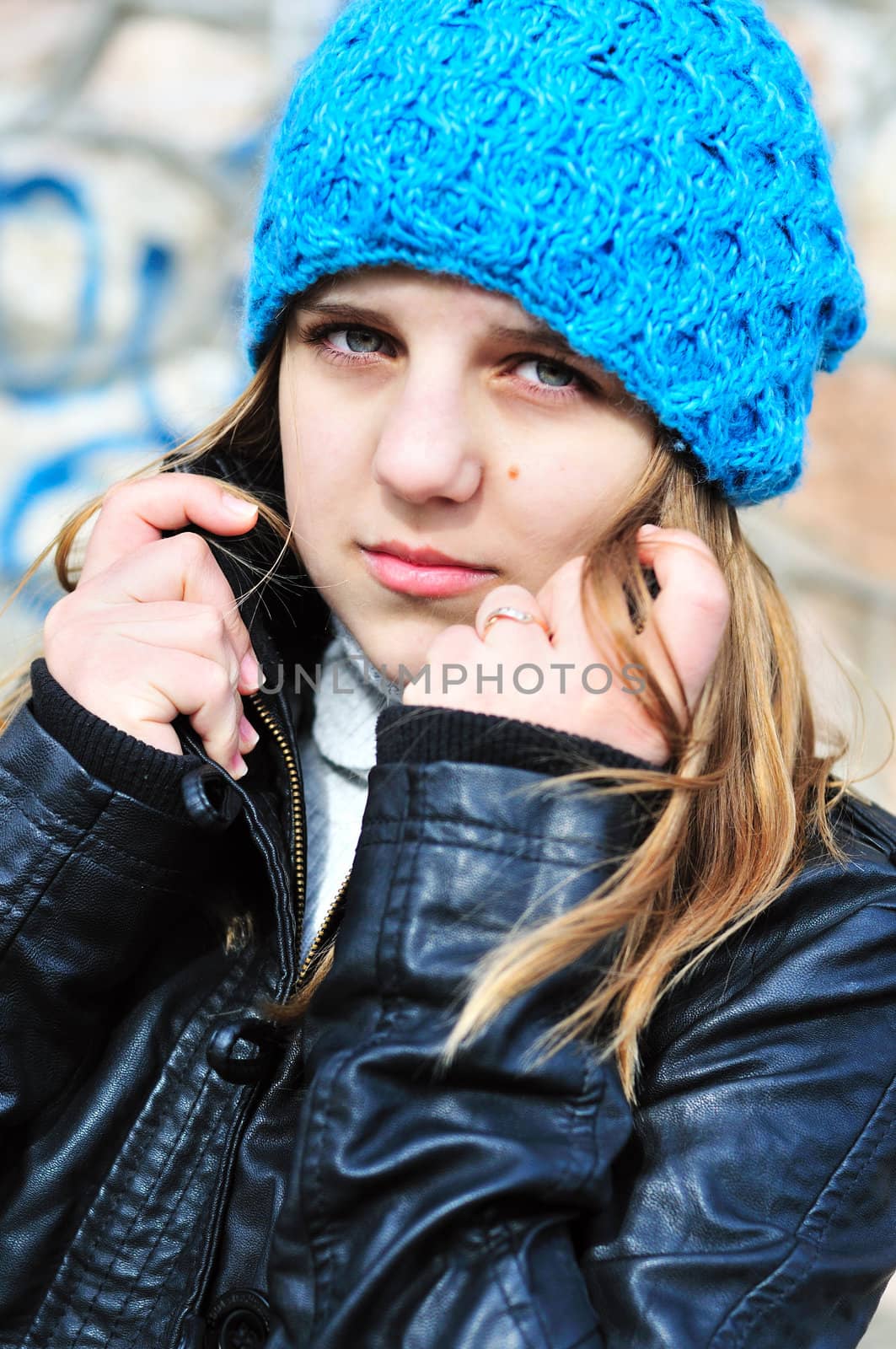 teen girl wearing blue hat and leather jacket