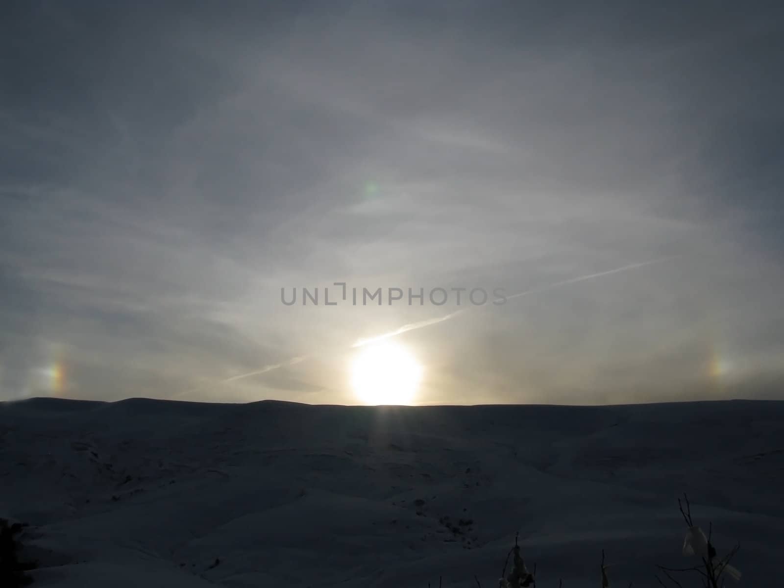 Plateau; a rainbow; the sun; beams; a ridge