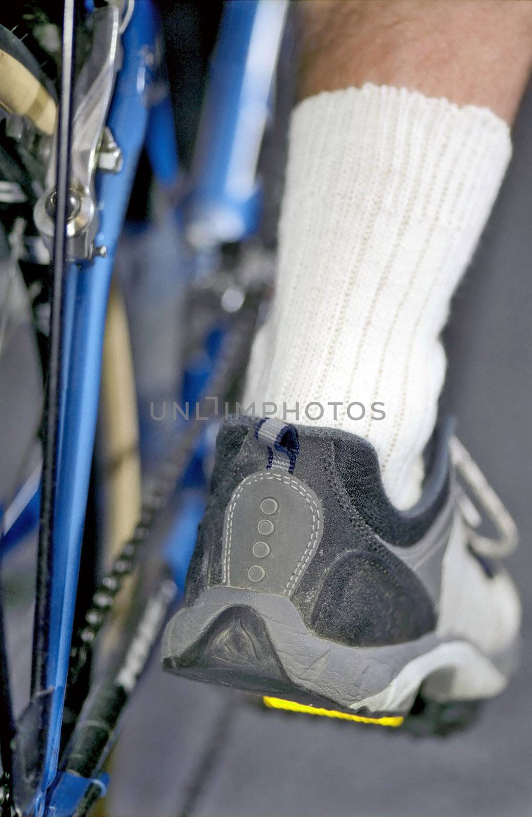 Cycle details and man's foot on pedal in lower position  by mulden