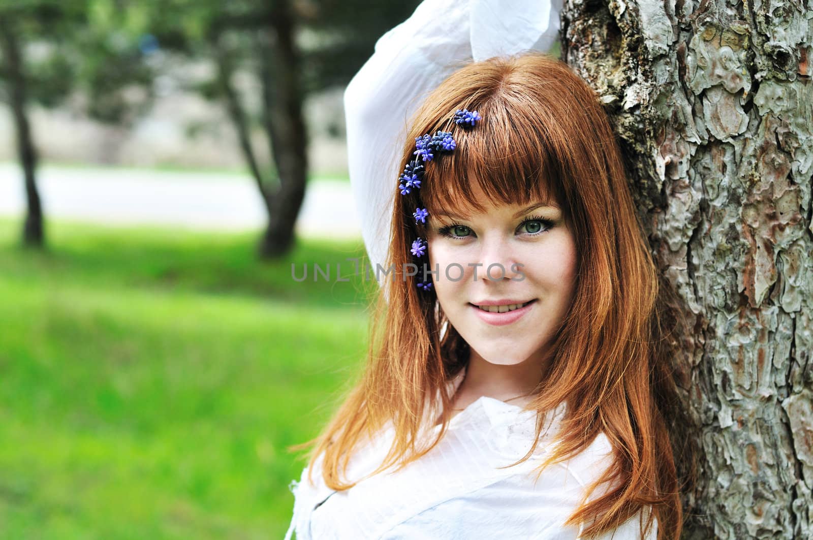  redheaded girl in the spring forest with flowers in her hair
