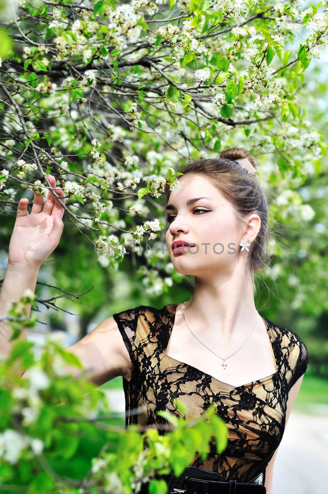 attractive  teen girl  standing in the spring blossom gardn
